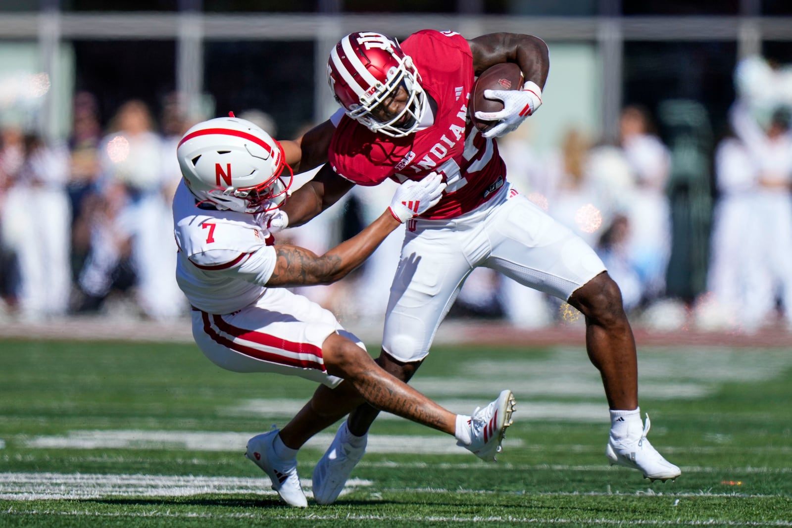 Indiana wide receiver Miles Cross, right, gets tackled by Nebraska defensive back Malcolm Hartzog Jr. (7) during the first half of an NCAA college football game in Bloomington, Ind., Saturday, Oct. 19, 2024. (AP Photo/AJ Mast)