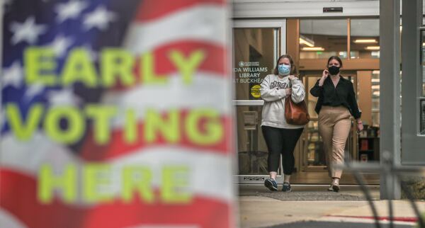 Kimberly Underwood (left) and sister Mary Wallace Underwood leave the Buckhead Library on the first day of early voting. (John Spink / John.Spink@ajc.com)