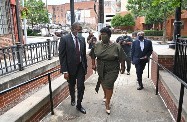 Atlanta school board executive administrator Pierre Gaither (left) and new Atlanta Public Schools Superintendent Lisa Herring talk before Herring is sworn in on June 30. (Hyosub Shin / Hyosub.Shin@ajc.com)