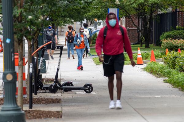 08/24/2020 - Atlanta, Georgia - Georgia State University students and individuals walk along Piedmont Avenue SE during the first day of classes at Georgia State University in Atlanta, Monday, August 24, 2020. (ALYSSA POINTER / ALYSSA.POINTER@AJC.COM)