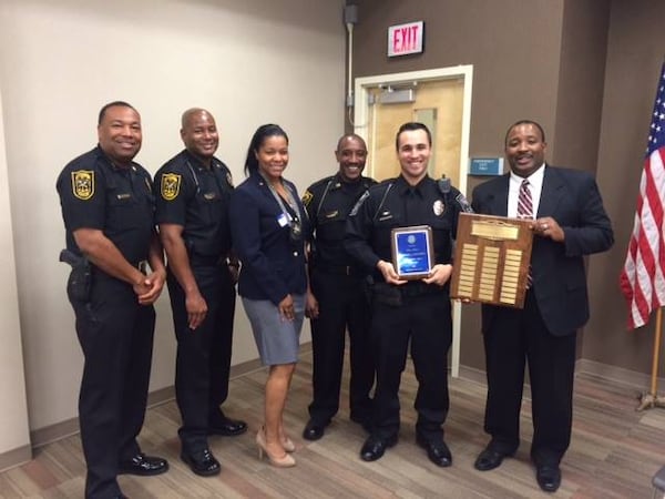 Veteran DeKalb County Police officer P.  Larscheid (holding blue plaque) was the Lions Club International’s Police Officer of the Year in 2014. The officer is now under fire after a video surfaced showing him beating a woman during a June arrest.