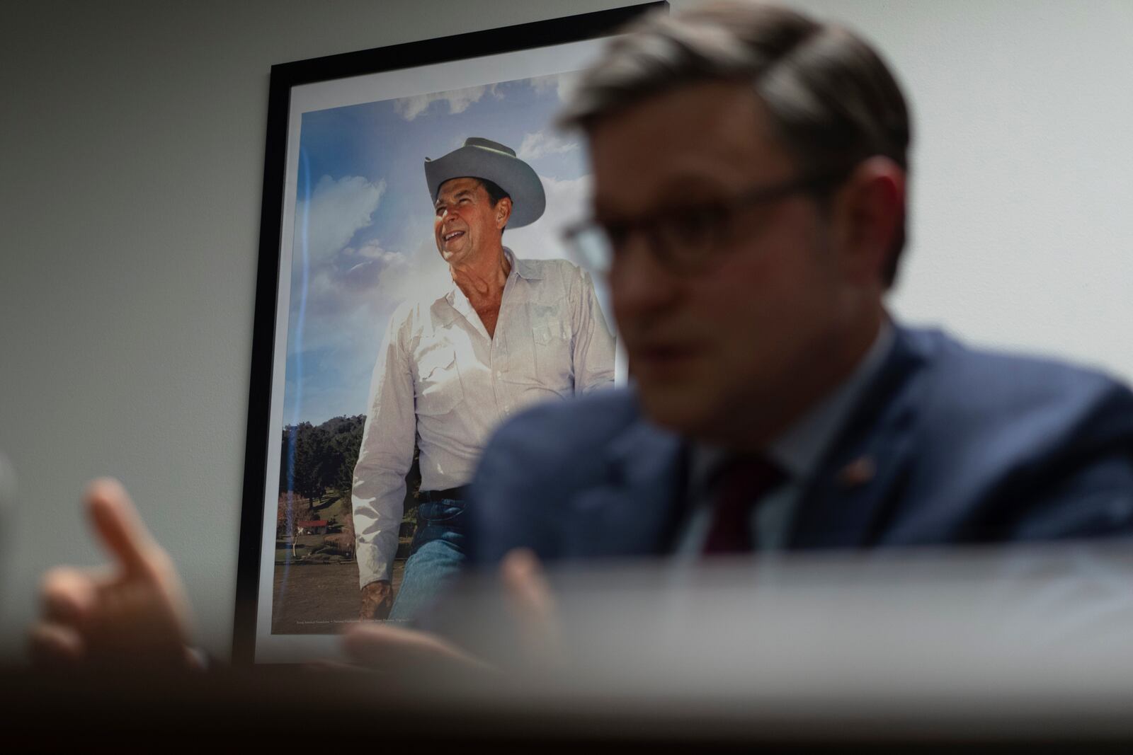 An image of former President Ronald Reagan is seen behind Speaker of the House Mike Johnson, R-La., during an interview with The Associated Press at the Lucas County Republican Party headquarters in Holland, Ohio, Saturday, Oct. 26, 2024. (AP Photo/Carolyn Kaster)