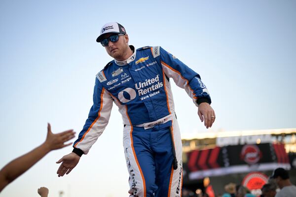 FILE - Austin Hill slaps hands with spectators during driver introductions before a NASCAR Cup Series auto race at Daytona International Speedway, Aug. 26, 2023, in Daytona Beach, Fla. (AP Photo/Phelan M. Ebenhack, File)