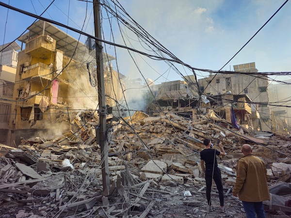 Residents check the site of an Israeli airstrike in Dahiyeh, Beirut, Lebanon, Wednesday, Nov. 13, 2024. (AP Photo/Hassan Ammar)