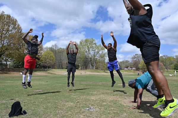 Que Smith (left) leads an exercise as people enjoy spring weather at Piedmont Park on Saturday, March 21, 2020. The park’s playground was closed but people found ways to enjoy the outdoors. HYOSUB SHIN / HYOSUB.SHIN@AJC.COM