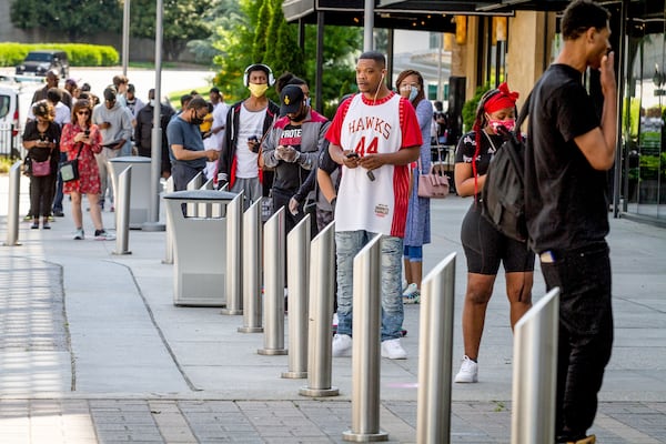 A long line formed outside of Lenox Square Mall before the doors opened Monday, but there were not many people in the mall in the afternoon. STEVE SCHAEFER / SPECIAL TO THE AJC