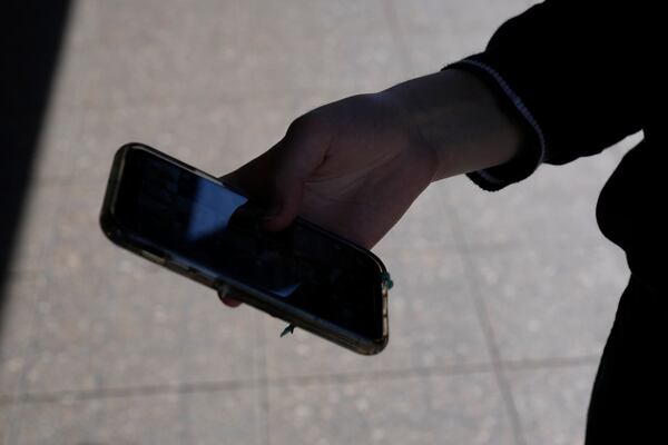 A teenage girl uses her phone in Sydney, Friday, Nov. 8, 2024. (AP Photo/Rick Rycroft)