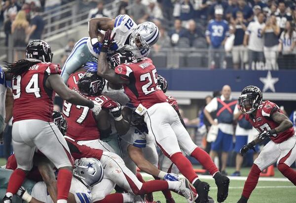 Dallas Cowboys running back Joseph Randle (21) leaps over Atlanta Falcons' Tyson Jackson (94), Grady Jarrett (97) and William Moore (25) as Ricardo Allen (37) watches for a touchdown in the first half of an NFL football game, Sunday, Sept. 27, 2015, in Arlington, Texas. (AP Photo/Michael Ainsworth)