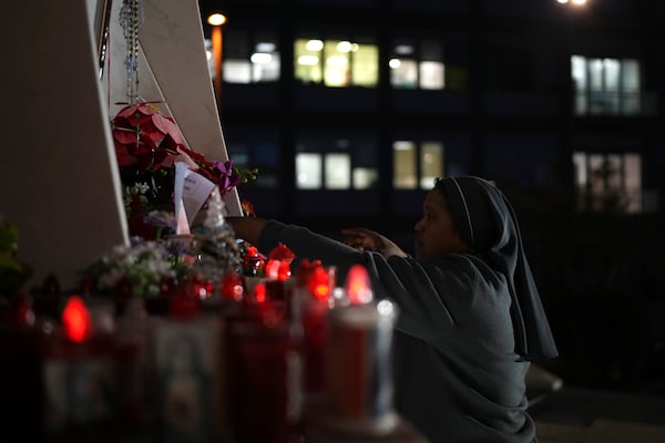 A nun adjusts candles in front of the Agostino Gemelli Polyclinic, in Rome, Saturday, Feb. 22, 2025, where the Pontiff has been hospitalized since Friday, Feb. 14. (AP Photo/Alessandra Tarantino)