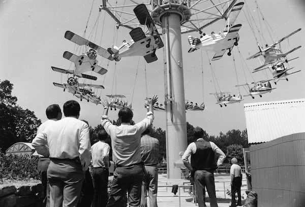 Officials of Six Flags Over Georgia watch as minor problems are corrected and a load of park patrons rise toward the top of the ride on June 20, 1984.