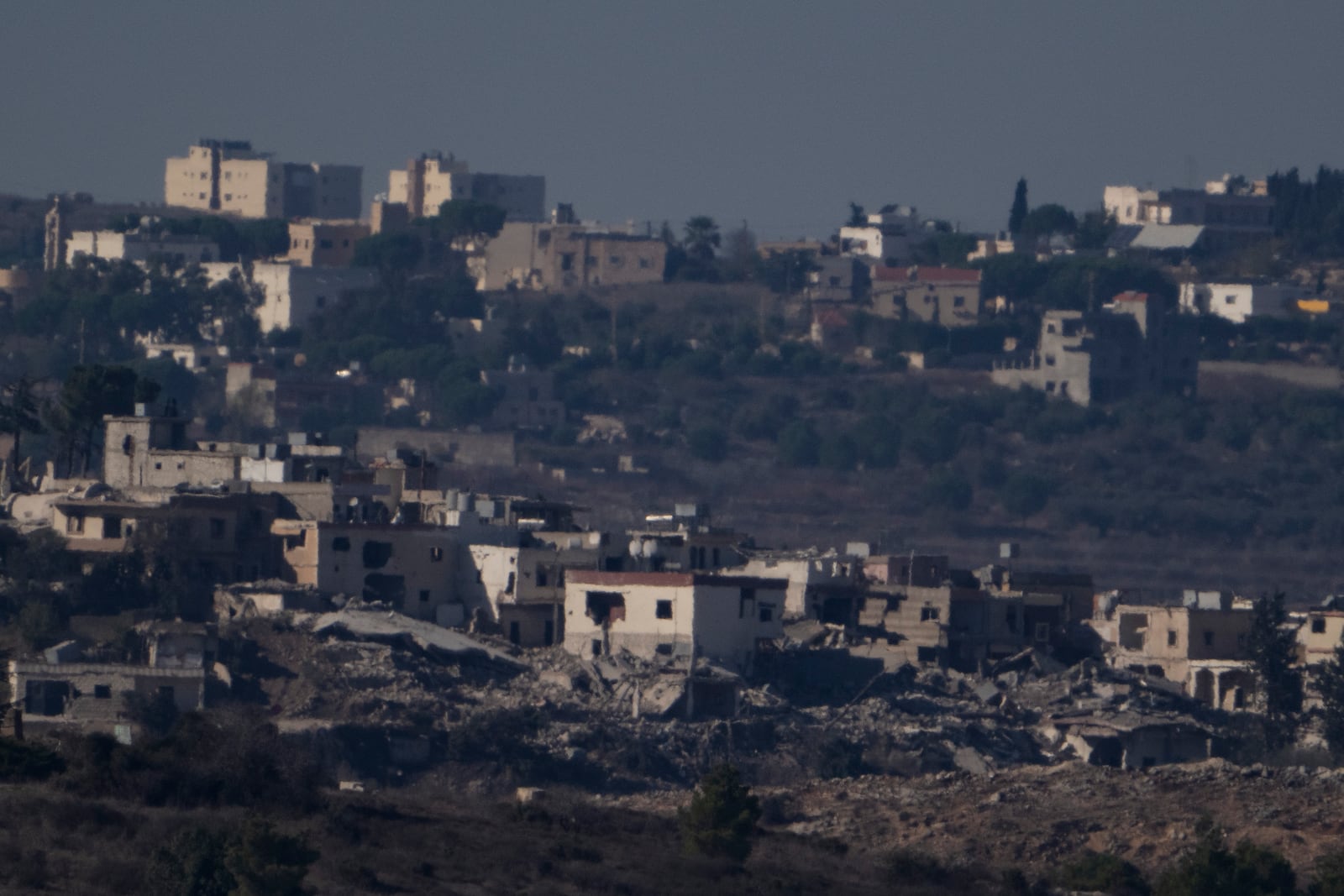 Destroyed buildings stand in an area in southern Lebanon as seen from northern Israel, Tuesday, Oct. 8, 2024. (AP Photo/Leo Correa)