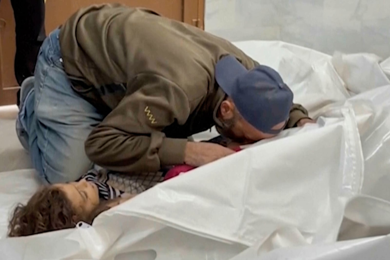 EDS NOTE: GRAPHIC CONTENT - A Palestinian kisses a relative killed in Israeli airstrikes, in a morgue in the city of Khan Younis, southern Gaza Strip, Friday, Oct. 25, 2024. (AP Photo)