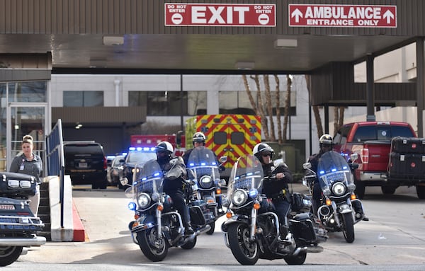 February 9, 2018 Atlanta - Henry County ambulance leaves escorted by a police motorcycle at Atlanta Medical Center, where two wounded Henry County sheriff's deputies were treated, on Friday, February 9, 2018. A Locust Grove police officer was killed and two Henry County sheriff's deputies were wounded when they tried to serve an arrest warrant Friday at a home on St. Francis Court, authorities said. HYOSUB SHIN / HSHIN@AJC.COM