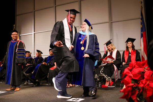 Herschel Walker strikes the Heisman Trophy pose with Anisa Zvonkovic, the dean of the University of Georgia College of Family and Consumer Sciences, during a ceremony on Thursday.