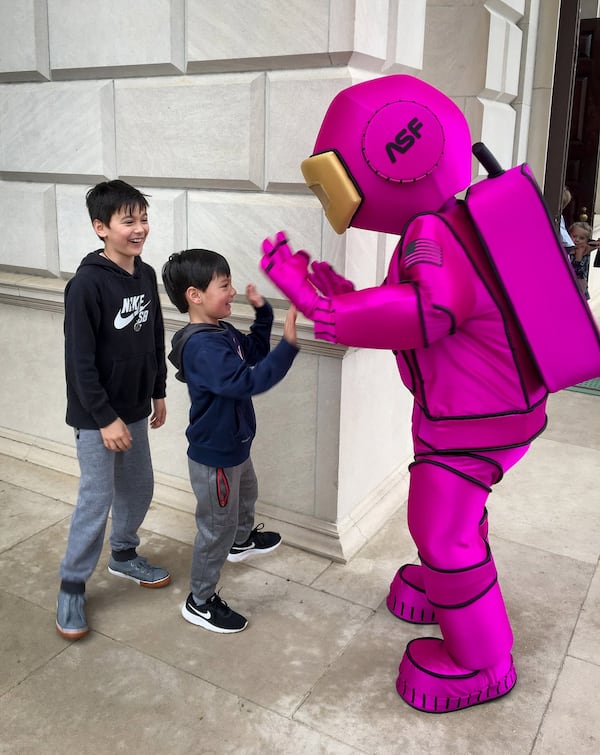 Sam Andres, 4, gets a high five from Atlanta Science Festival mascot, Alex, Saturday morning at Glenn Memorial United Methodist Church, while brother, Smith Andres, 9, looks on. The Andres family attended the Wow in the World Pop Up Party, the kick-off event for the two-week long festival. FRANK REDDY/ SPECIAL TO THE AJC