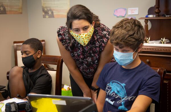 Recent UGA graduate Sophia Ramirez (C) helps David Walraven, 12, with his schoolwork at the Nelson Elder Care Law office in Marietta. STEVE SCHAEFER FOR THE ATLANTA JOURNAL-CONSTITUTION