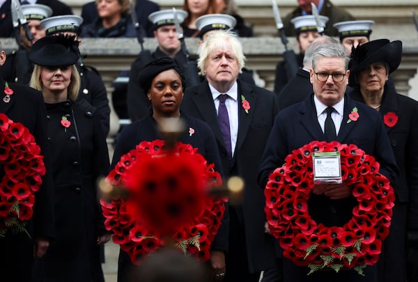 British Prime Minister Keir Starmer, front right, and Conservative Party leader Kemi Badenoch, front left, carry wreaths, as former Prime Ministers Boris Johnson, second row center, Liz Truss, second row left, and Theresa May, second row right, look on as they attend the annual Remembrance Sunday ceremony at The Cenotaph in London, England, Sunday, Nov. 10, 2024. (Toby Melville/Pool Photo via AP)