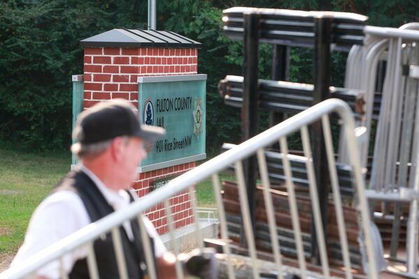 A worker takes down media barriers near the Rice Street entrance of Fulton County Jail on Friday, August 25, 2023. (Natrice Miller/natrice.miller@ajc.com)