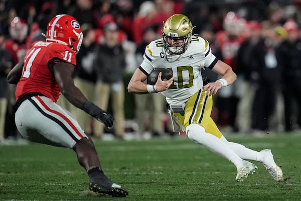 Georgia Tech quarterback Haynes King (10) runs against Georgia linebacker Jalon Walker (11) during the first half of an NCAA college football game, Friday, Nov. 29, 2024, in Athens, Ga. (AP Photo/Mike Stewart)