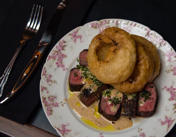 Tavern steak au poivre with onion rings at Golden Eagle, served on kitschy china befitting the restaurant’s theme. CONTRIBUTED BY HENRI HOLLIS