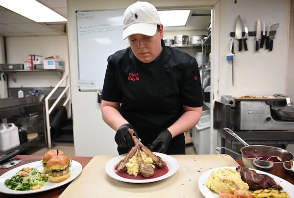 Chef Kayla Solomon-Gatti prepares food at The Swan Coach House Restaurant. Proceeds benefit the Atlanta visual arts community.​​​ (Hyosub Shin / AJC)