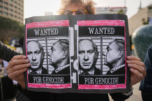 Demonstrators protest against Prime Minster Benjamin Netanyahu outside the court in Tel Aviv Tuesday Dec. 10, 2024. Netanyahu is set to take the stand on Tuesday in his long-running trial for alleged corruption.(AP Photo/Ariel Schalit)