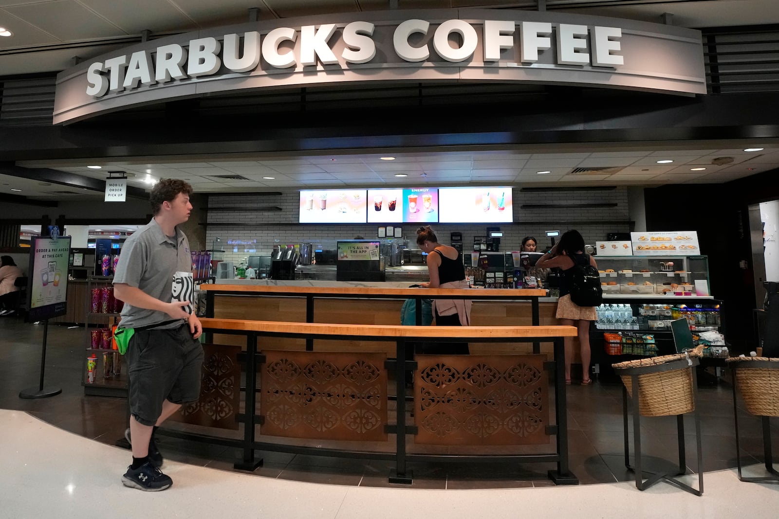 FILE - A patron walks out of a Starbucks at Phoenix Sky Harbor International Airport July 19, 2024, in Phoenix. (AP Photo/Ross D. Franklin, File)