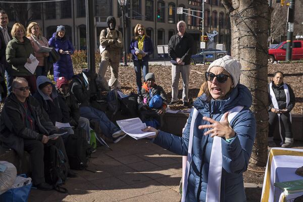 The Rev. Monica Mainwaring, vicar at Church of the Common Ground, presents the word during a Church of the Common Ground Christmas Eve service for the homeless at Woodruff Park in Atlanta on Monday, December 24, 2018.