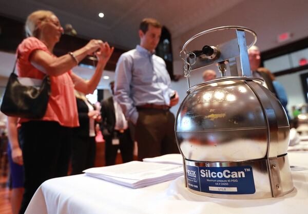 Local residents look over a summa canister used to collect air samples sitting on a table during the town hall meeting on ethylene oxide gas from the nearby BD Bard plant in Covington. Curtis Compton/ccompton@ajc.com