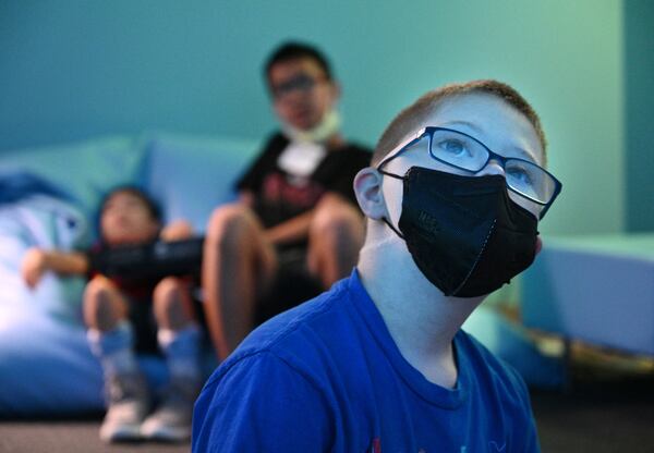 Summer camp participant Harrison plays and learns using technology in a sensory room during a summer camp for children with special needs at Lekotek of Georgia in Tucker on Tuesday, July 12, 2022. (Hyosub Shin / Hyosub.Shin@ajc.com)