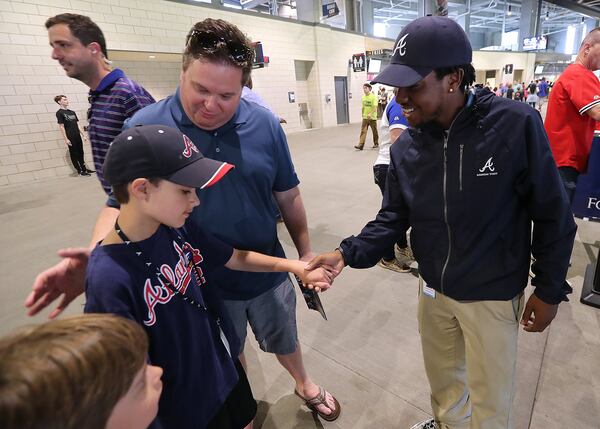 Atlanta Braves guest services employee Christopher Waters welcomes Gavi and his dad Todd Surden to their seats. Curtis Compton/ccompton@ajc.com