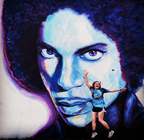 A girl leaps in the air while being photographed in front of a mural featuring Prince created by artist Mayling Pao in West Palm Beach, December 30, 2016. (Greg Lovett / The Palm Beach Post)