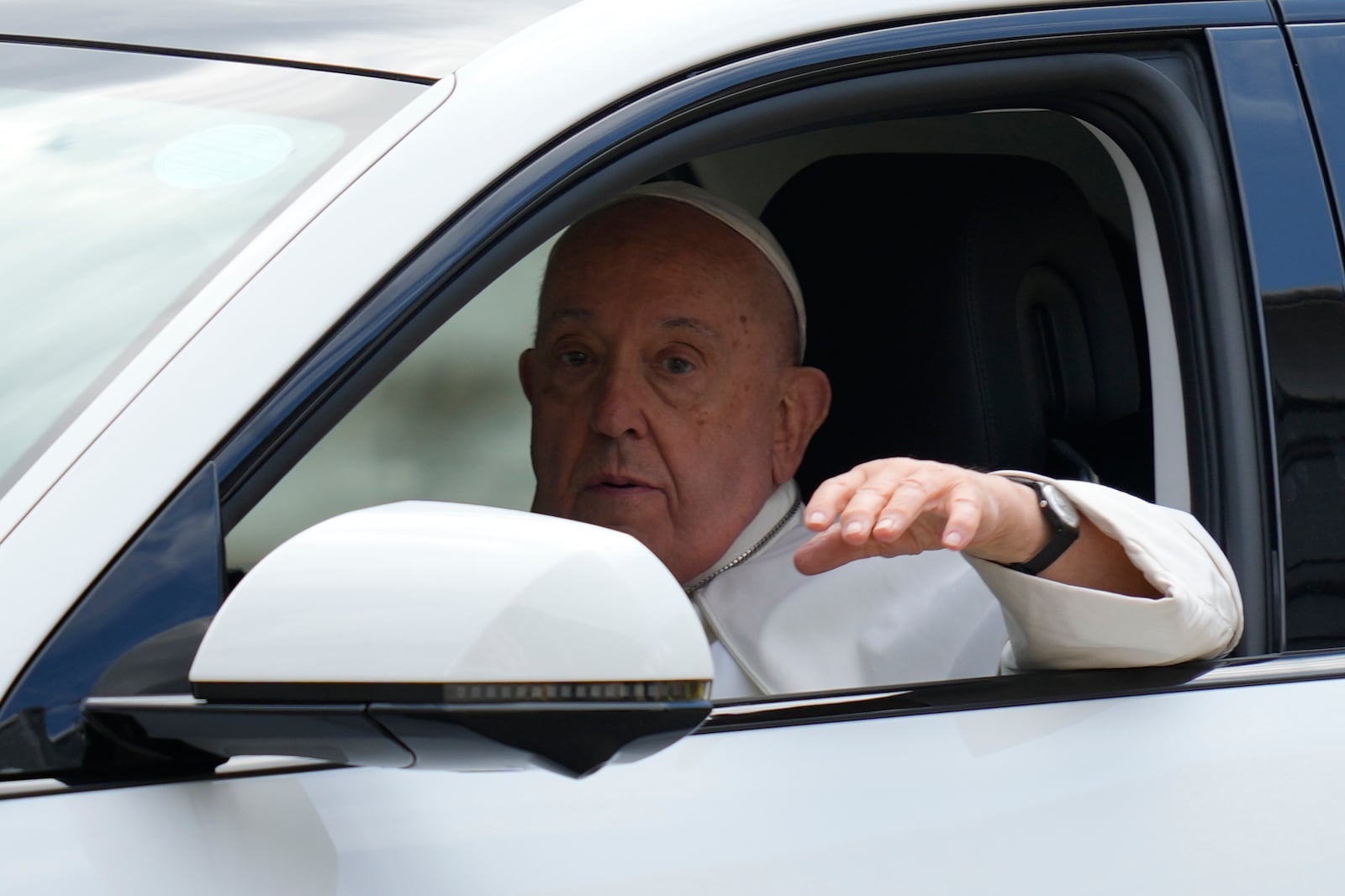 Pope Francis waves from the car, as he leaves from the Parliament House in Singapore, Thursday, Sept. 12, 2024. (AP Photo/Vincent Thian)