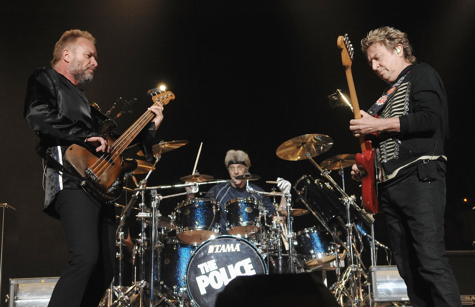 Lead vocalist and bassist Sting, left, guitarist Andy Summers, right, and drummer Stewart Copeland of The Police perform their farewell concert at Madison Square Garden on Thursday, Aug. 7, 2008 in New York. (AP Photo/Evan Agostini)