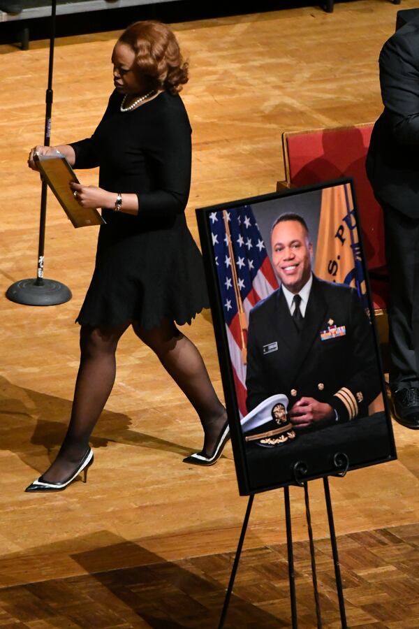 Tiara Cunningham walks past an image of her brother during a memorial service for CDC researcher Timothy Cunningham, who was pulled from the Chattahoochee River after being missing for seven weeks, held Saturday at Morehouse April 21, 2018. (John Amis Contributed)