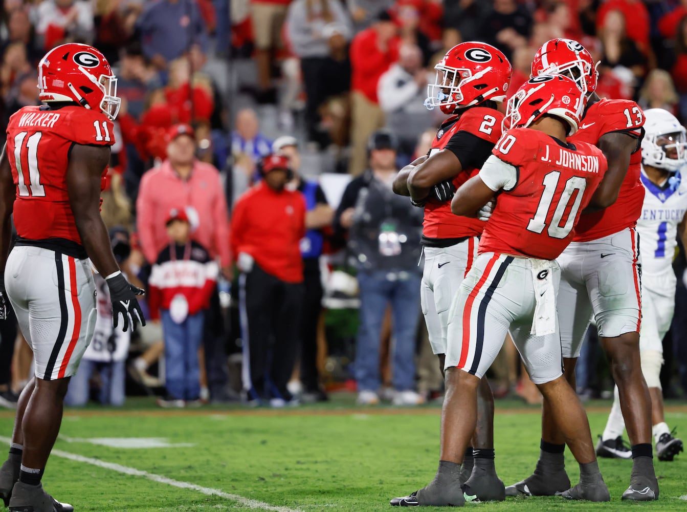 Georgia linebacker Jalon Walker (11),  linebacker Smael Mondon Jr. (2),  linebacker Jamon Dumas-Johnson (10) and  defensive lineman Mykel Williams (13) celebrate their sack of  Kentucky Wildcats quarterback Devin Leary (13).  (Bob Andres for the Atlanta Journal Constitution)