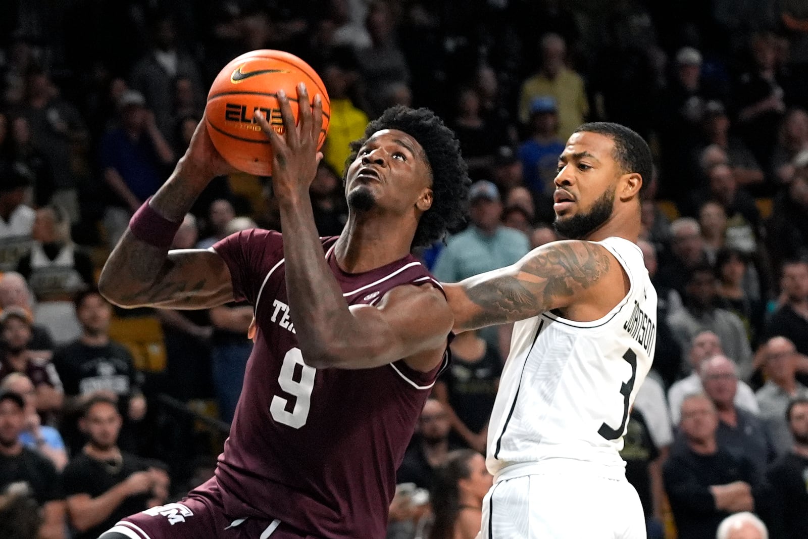 Texas A&M forward Solomon Washington (9) goes past Central Florida guard Darius Johnson (3) to shoot during the first half of an NCAA college basketball game, Monday, Nov. 4, 2024, in Orlando, Fla. (AP Photo/John Raoux)