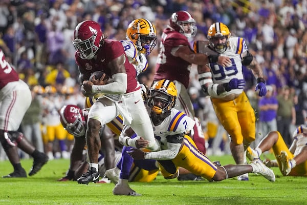 Alabama quarterback Jalen Milroe (4) breaks free from LSU safety Jardin Gilbert (2) on a touchdown carry in the second half an NCAA college football game in Baton Rouge, La., Saturday, Nov. 9, 2024. (AP Photo/Gerald Herbert)