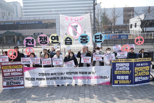 Protesters shout slogans during a press conference demanding to stop the upcoming Freedom Shield military exercise between the U.S. and South Korea, near the Defense Ministry in Seoul, South Korea, Monday, March 10, 2025. The letters read "Stop, War exercise." (AP Photo/Lee Jin-man)