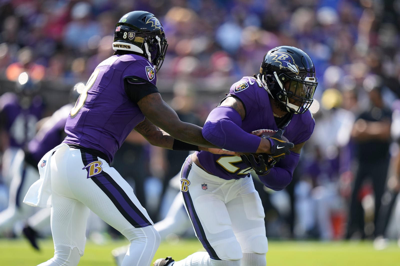 Baltimore Ravens quarterback Lamar Jackson (8) hands off to running back Derrick Henry, right, during the first half of an NFL football game against the Washington Commanders Sunday, Oct. 13, 2024, in Baltimore. (AP Photo/Stephanie Scarbrough)