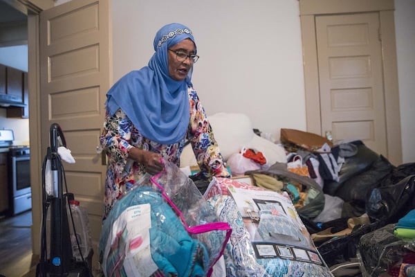 Osman goes through donated items she collected for refugees at her residence in Clarkston. ALYSSA POINTER/ALYSSA.POINTER@AJC.COM