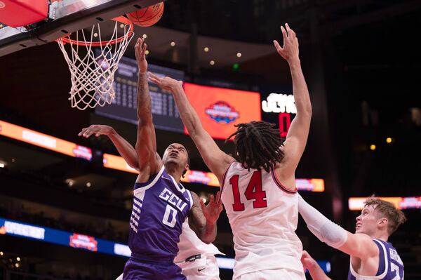 Grand Canyon guard Ray Harrison (0) reaches to put the ball in the net as Georgia forward Asa Newell (14) defends during the first half of an NCAA college basketball game on Saturday, Dec. 14, 2024, in Atlanta. (AP Photo/Kathryn Skeean)