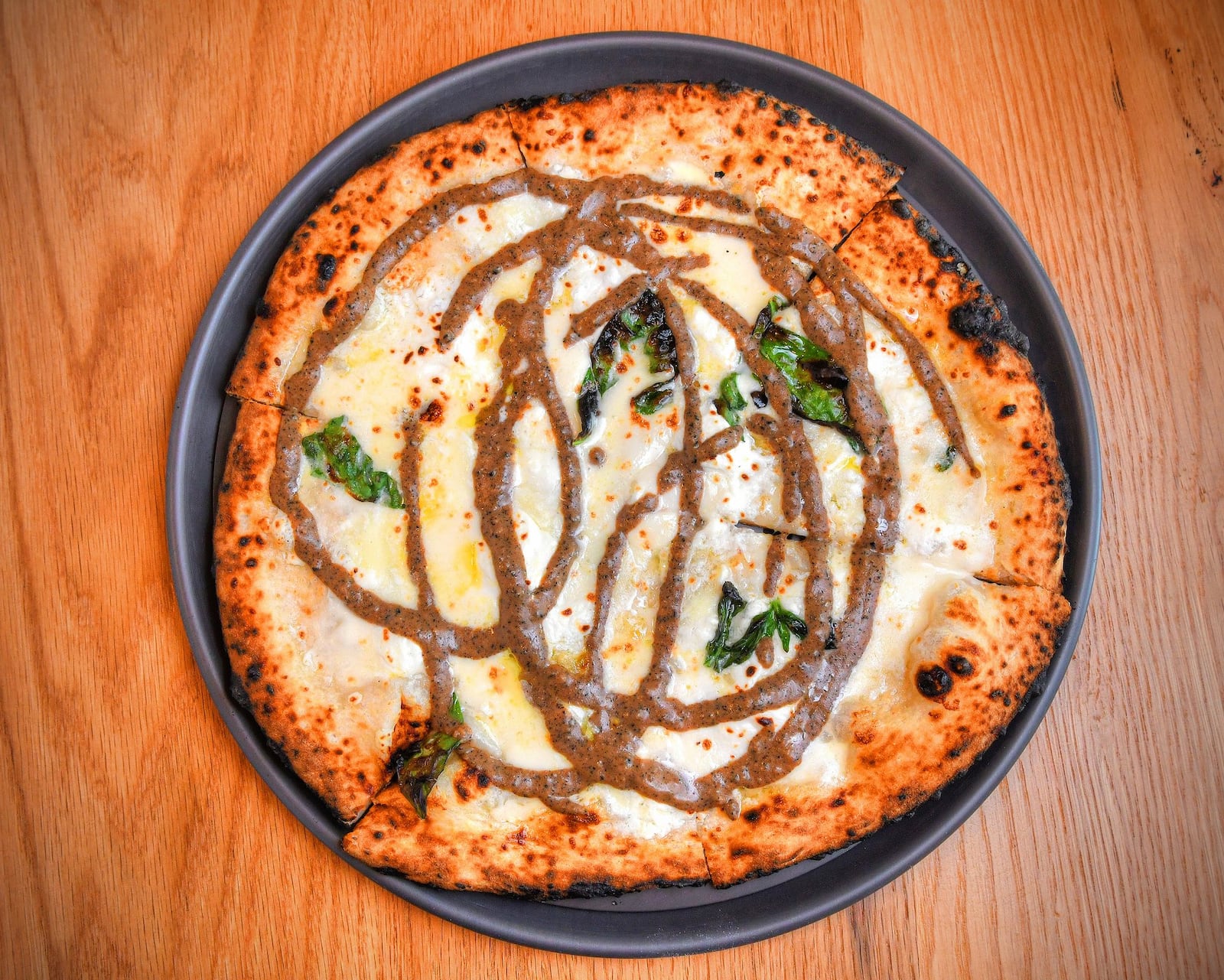 Pizza with burrata, robiolina, black truffle and fresh basil. First CONTRIBUTED BY CHRIS HUNT PHOTOGRAPHY