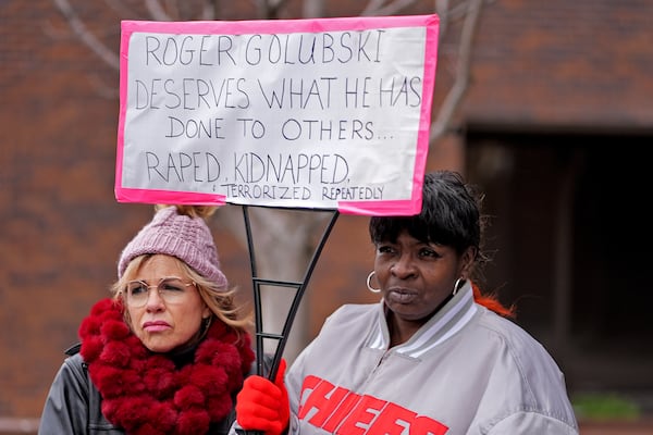 Lesa Mensa, left, and Anita Randle listen to a speaker at a rally outside the federal courthouse on was was to be the opening day for a trial for former police detective Roger Golubski, Monday, Dec. 2, 2024, in Topeka, Kan. (AP Photo/Charlie Riedel)