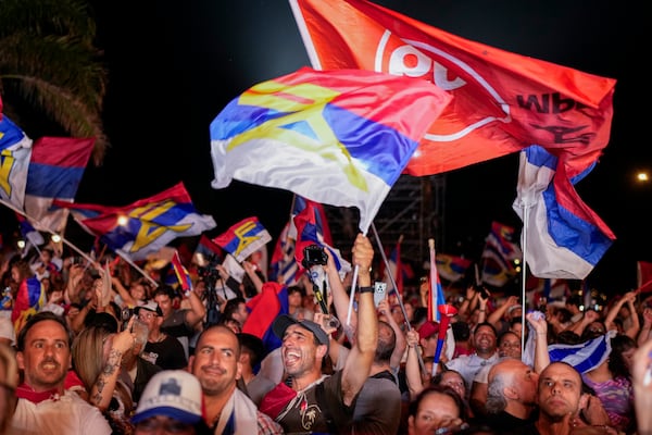 Supporters of Yamandu Orsi, candidate for the Broad Front (Frente Amplio), celebrate early results after polls closed in the presidential run-off election in Montevideo, Uruguay, Sunday, Nov. 24, 2024. (AP Photo/Natacha Pisarenko)