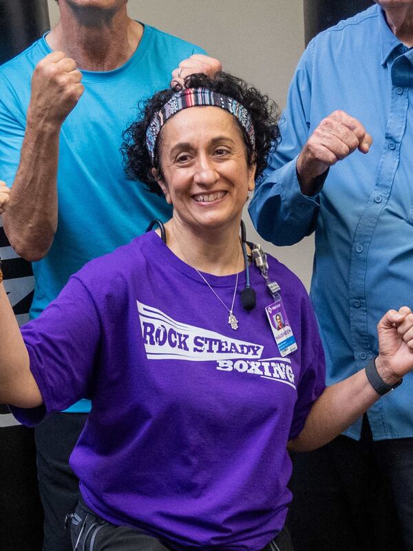 Rock Steady Boxing instructor Nausheen Quraishy poses with her class at the Kennestone Health Place at Kennestone Hospital in Kennesaw. She runs the class to help people with Parkinson's try to regain their strength. She used her own personal battles to help her inspire others to fight for their future. (Phil Skinner for the AJC)