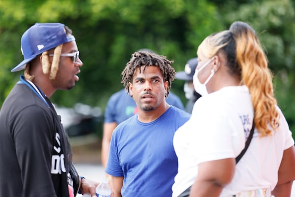 Residents of Mechanicsville Kenny Redding (right) and Terence Denson (center) speak to a neighbor after a peaceful rally held at Windsor Plaza on Tuesday, August 9, 2022, where gunfire left two people dead Sunday and four injured, including a 6-year-old girl. Miguel Martinez / miguel.martinezjimenez@ajc.com 