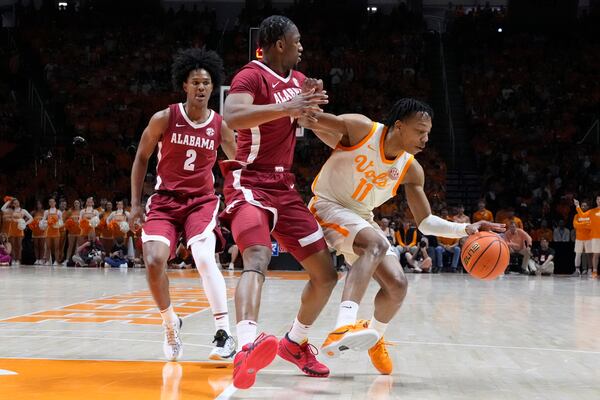 Tennessee guard Jordan Gainey (11) drives against Alabama's Aden Holloway (2) and Mouhamed Dioubate, center, in the first half of an NCAA college basketball game Saturday, March 1, 2025, in Knoxville, Tenn. (AP Photo/Mark Humphrey)