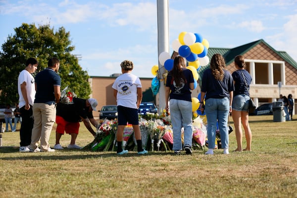 Mourners leave flowers and balloons outside Apalachee High School after Wednesday's shooting.