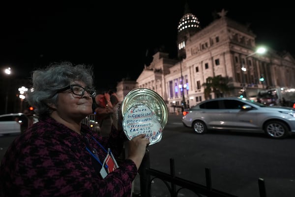 A woman protests outside the Congress after Argentina's President Javier Milei delivered the annual State of the Nation address, which marks the start of the legislative year, in Buenos Aires, Argentina, Saturday, March 1, 2025. (AP Photo/Rodrigo Abd)